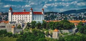 Beautiful panoramic view of Bratislava Castle towering over the Slovakian cityscape, surrounded by lush greenery.