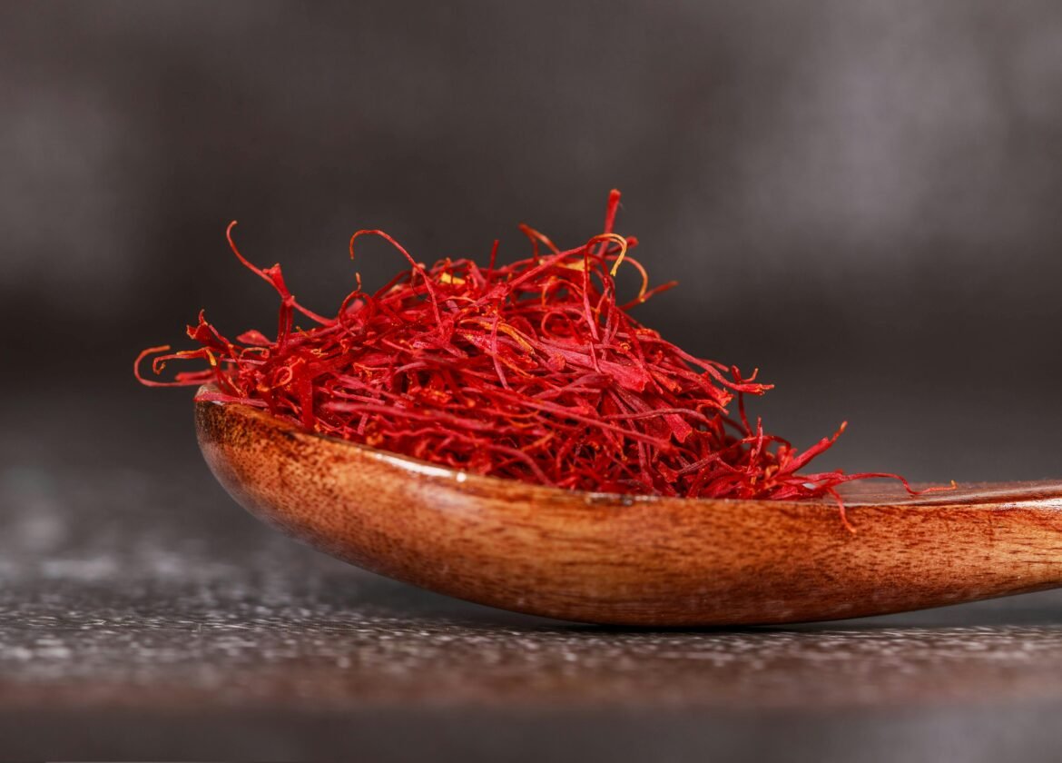 Primer plano detallado de hilos de azafrán vibrantes en una cuchara de madera, perfecto para imágenes culinarias.