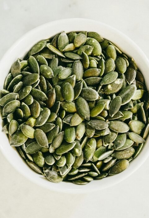 Un tazón lleno de semillas de calabaza verdes frescas, ideal para una alimentación saludable.